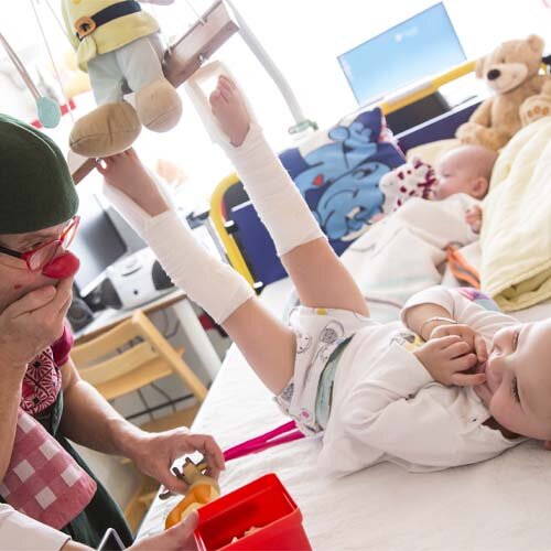 CliniClown met rode neus en baby.